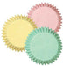 Set of pastel baking cupcake liners in three colors: pale yellow, soft pink, and light mint green, arranged overlapping with ridged edges facing outward.