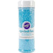 Clear plastic container with a white lid, filled with blue sparkling sugar. Label includes the Wilton logo and the word 'sprinkles' in blue text.